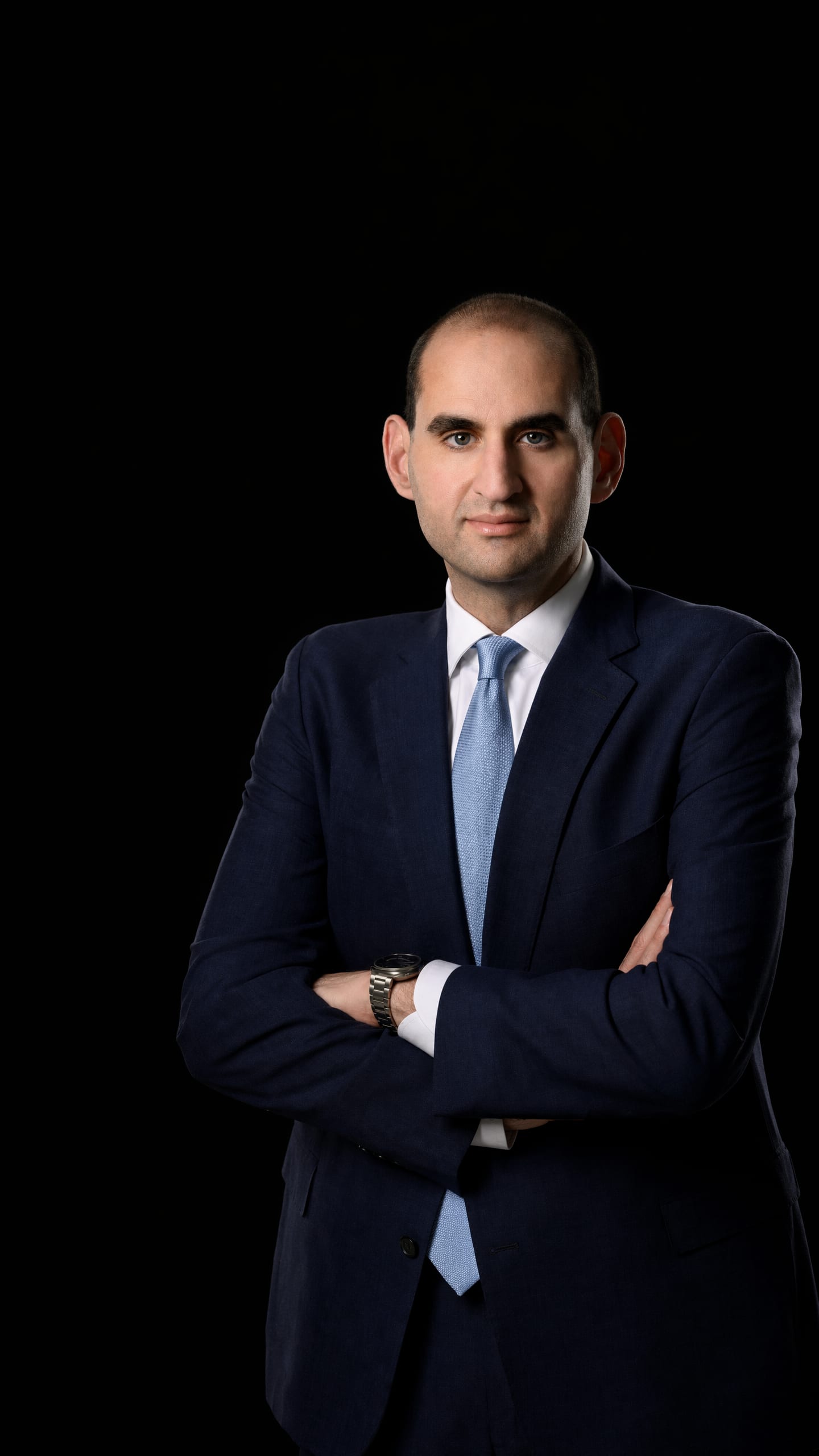 Jason Turkish, President and Managing Partner of Nyman Turkish PC, in a navy suit with arms crossed against a dark field.